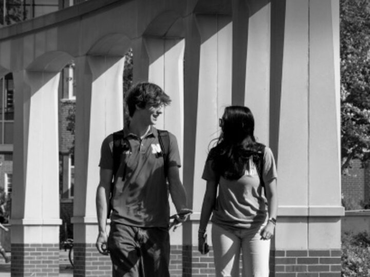 Raikes School students Gannett Bishop and Nina Glick walk along the columns outside of the Kauffman Academic Residential Center.